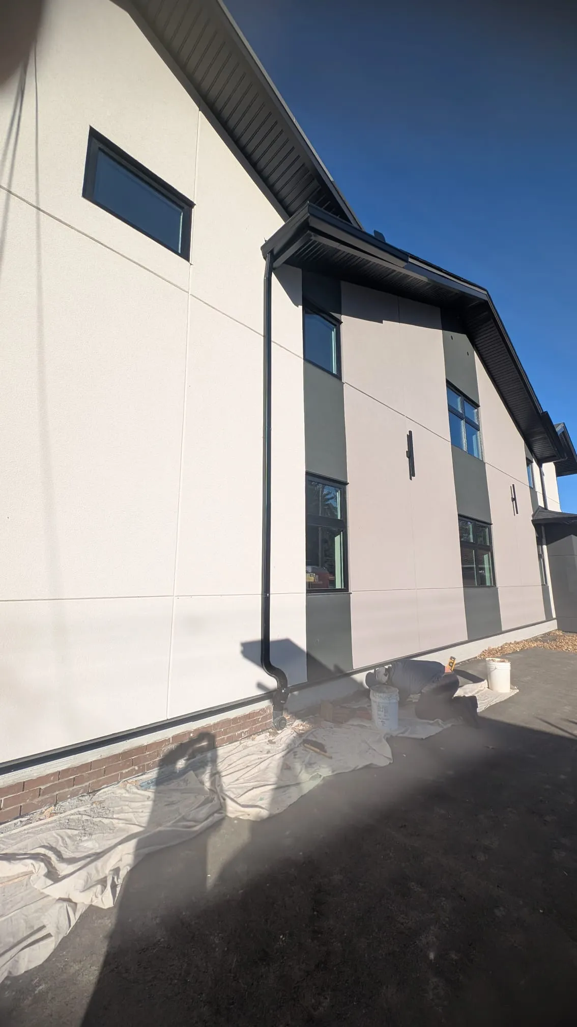 ACR Construction modern panel cladding with dark fascia and downspout